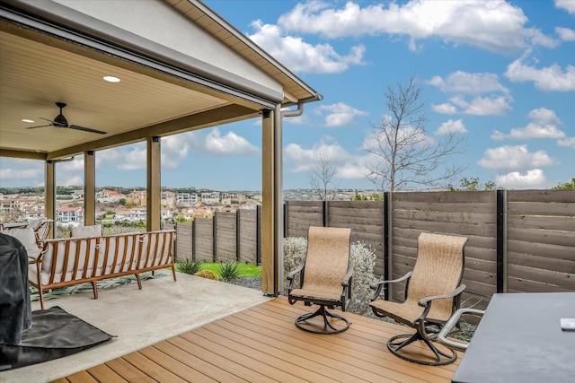 deck with a fenced backyard and a ceiling fan