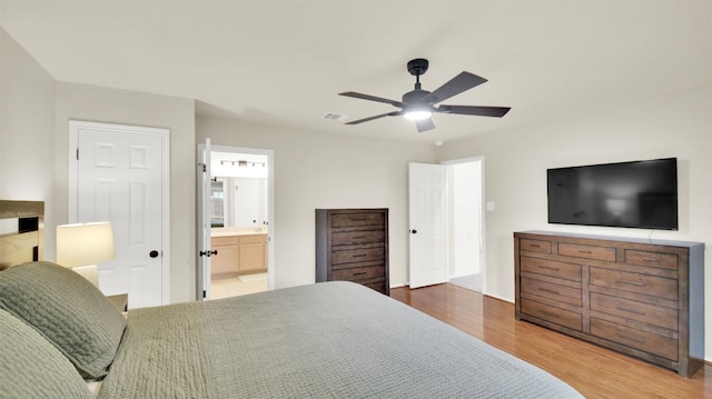 bedroom with connected bathroom, visible vents, ceiling fan, and wood finished floors