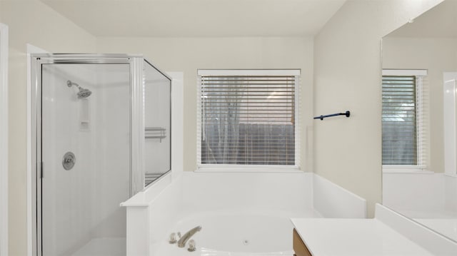 bathroom featuring a jetted tub, a stall shower, and vanity