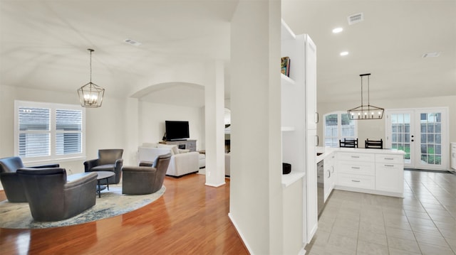 interior space featuring white cabinetry, visible vents, a chandelier, and a wealth of natural light