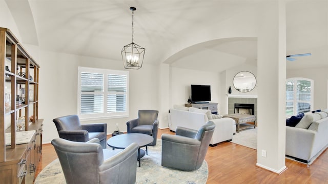 living area with a tile fireplace, plenty of natural light, light wood-style flooring, and ceiling fan