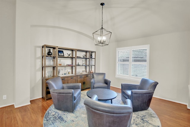 living area with a chandelier, light wood-type flooring, and baseboards