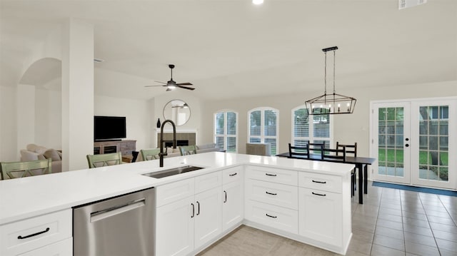 kitchen featuring a sink, open floor plan, light countertops, dishwasher, and decorative light fixtures