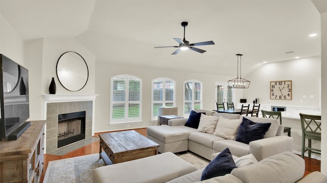 living area featuring vaulted ceiling, recessed lighting, a fireplace, and light wood-style floors