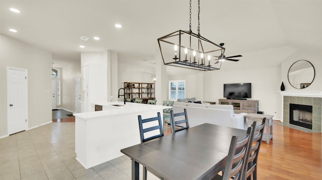 dining space featuring recessed lighting, a fireplace, baseboards, and ceiling fan with notable chandelier