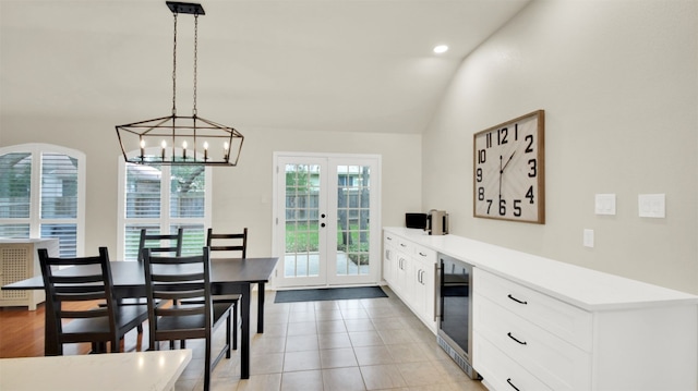 dining space featuring light tile patterned floors, recessed lighting, beverage cooler, vaulted ceiling, and french doors