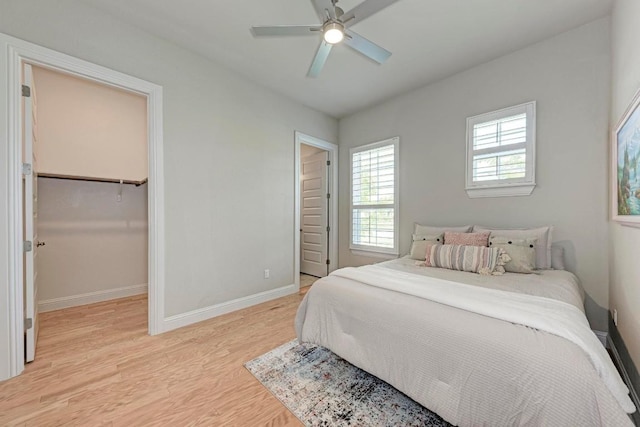 bedroom featuring light wood-style flooring, baseboards, and a ceiling fan