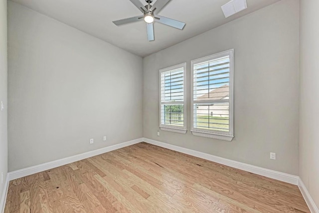 empty room featuring light wood finished floors, baseboards, visible vents, and ceiling fan