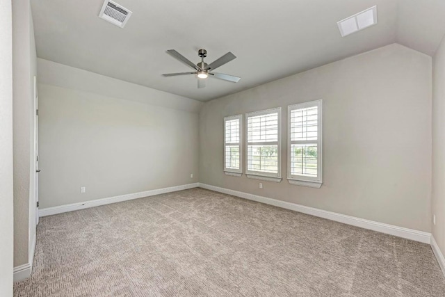 unfurnished room featuring lofted ceiling, carpet floors, baseboards, and visible vents