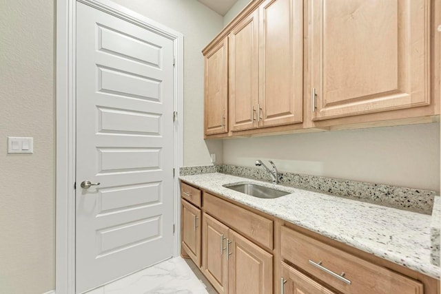 washroom featuring marble finish floor and a sink