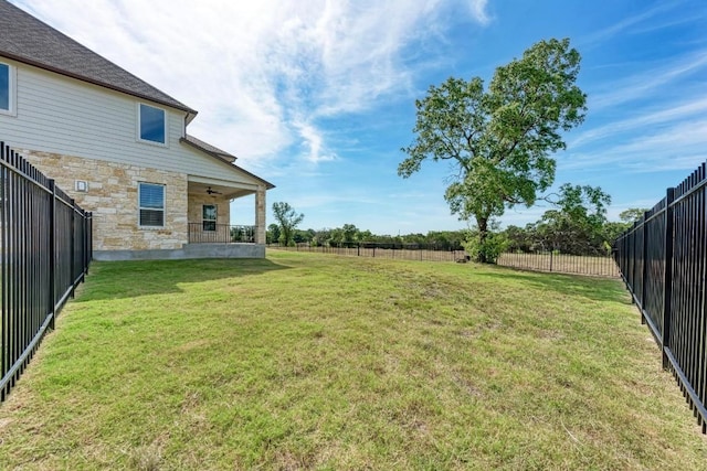 view of yard with a fenced backyard and a ceiling fan