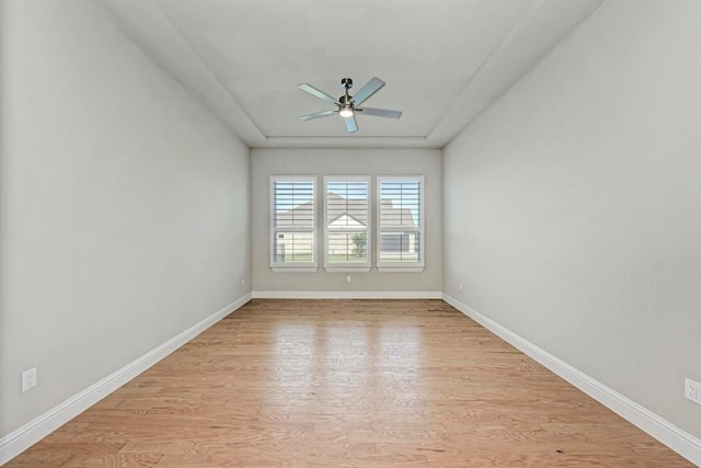 unfurnished room with light wood finished floors, baseboards, and a ceiling fan