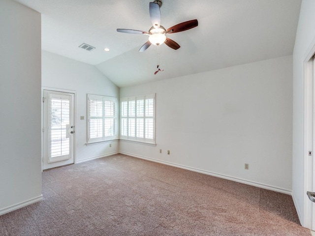 carpeted empty room with lofted ceiling, ceiling fan, plenty of natural light, and visible vents