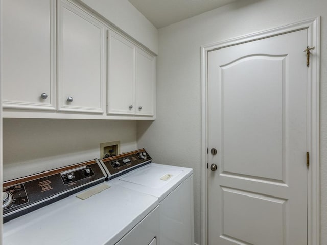 washroom featuring cabinet space and washer and clothes dryer