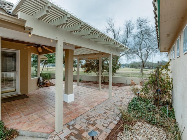 view of patio with ceiling fan, fence, and a pergola