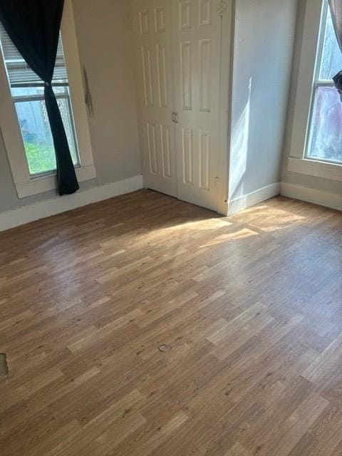 unfurnished bedroom with wood finished floors and baseboards