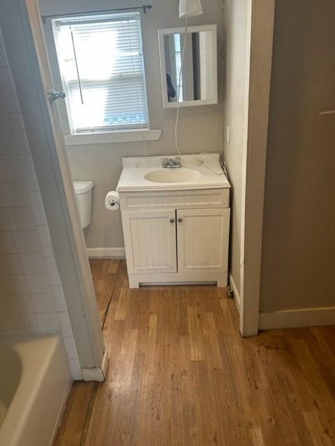 full bathroom with baseboards, vanity, toilet, and wood finished floors