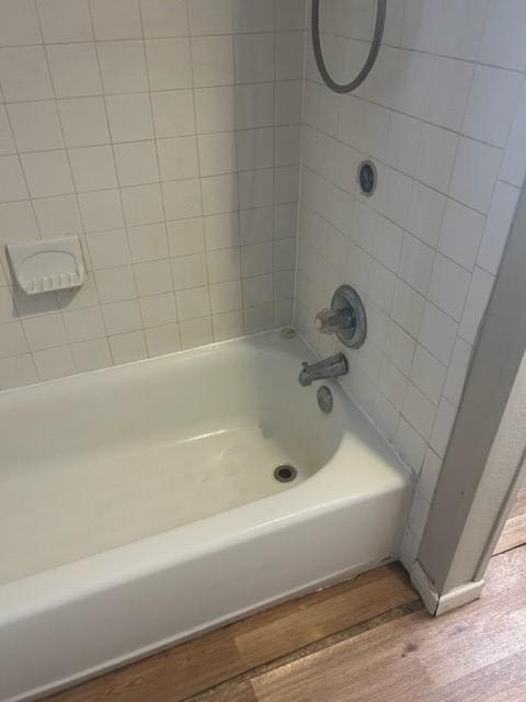 bathroom with bathtub / shower combination and wood finished floors