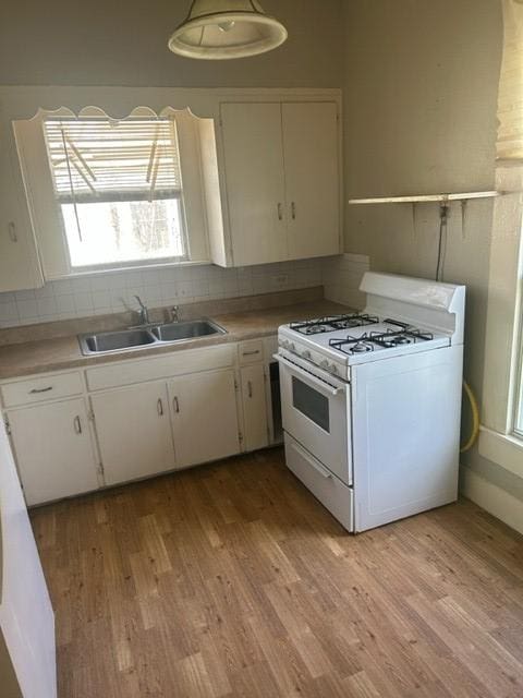 kitchen featuring light wood-style floors, white cabinets, white range with gas cooktop, and a sink