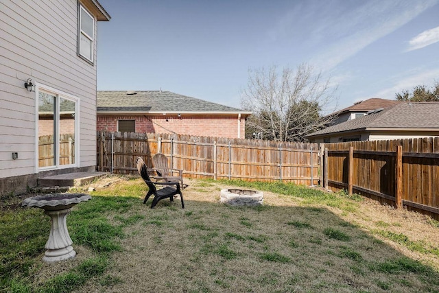 view of yard featuring an outdoor fire pit and fence