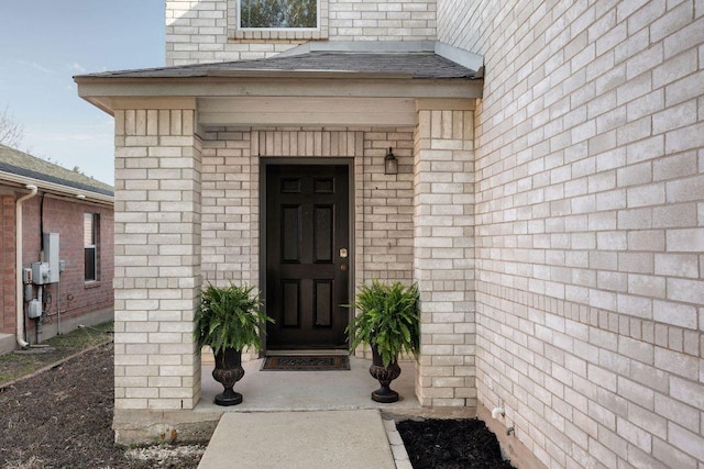 entrance to property featuring a shingled roof