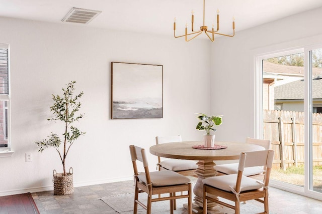 dining space with a notable chandelier, a wealth of natural light, visible vents, and baseboards