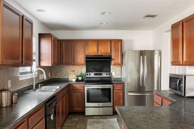 kitchen featuring visible vents, dark countertops, appliances with stainless steel finishes, under cabinet range hood, and a sink