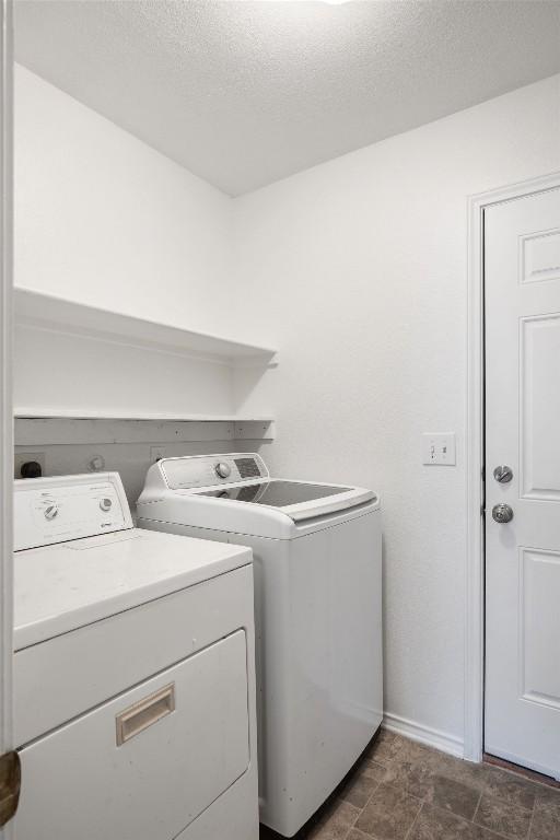 clothes washing area featuring laundry area, washer and clothes dryer, and a textured ceiling