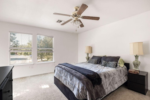 carpeted bedroom featuring a ceiling fan, visible vents, and baseboards