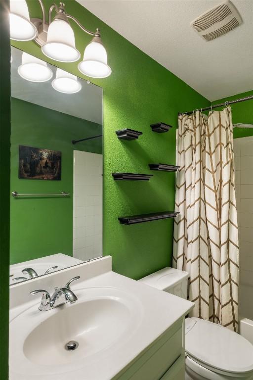 bathroom with toilet, visible vents, and vanity