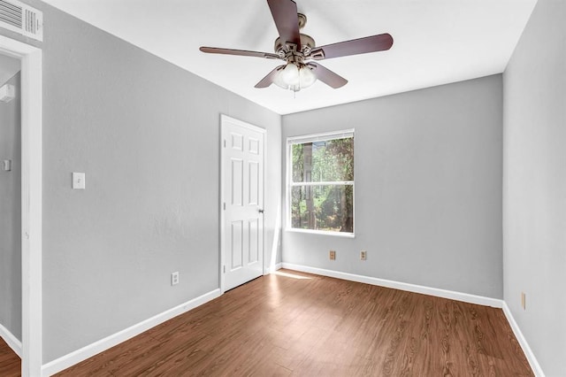 unfurnished room with baseboards, visible vents, and wood finished floors