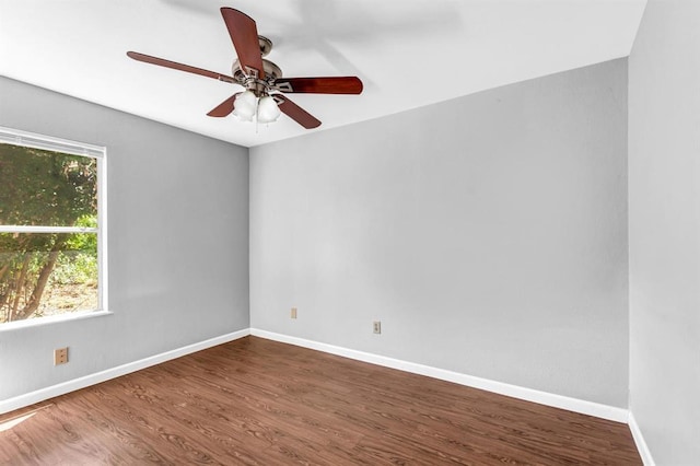 unfurnished room with a ceiling fan, baseboards, and wood finished floors