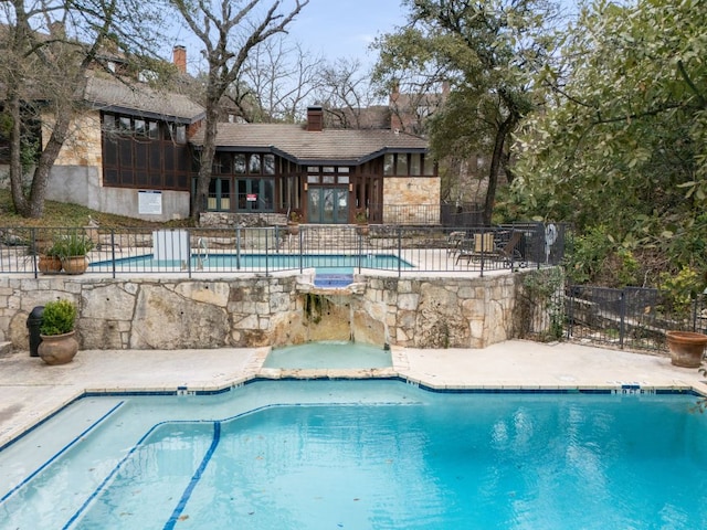 community pool featuring a patio and fence