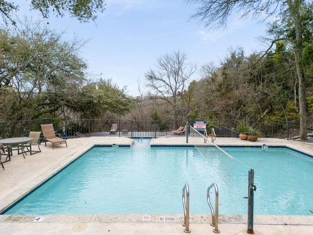 community pool featuring a patio area and fence