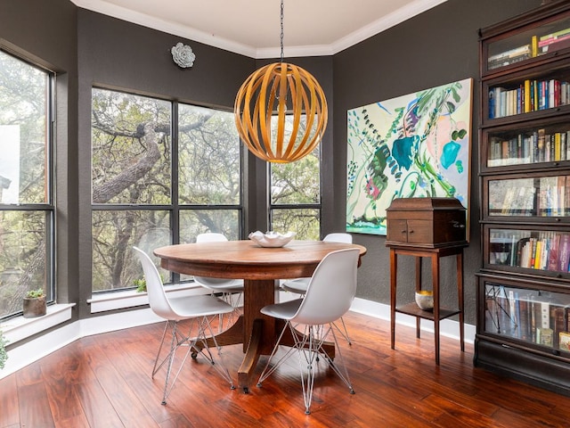 dining space with ornamental molding, a wealth of natural light, baseboards, and wood finished floors