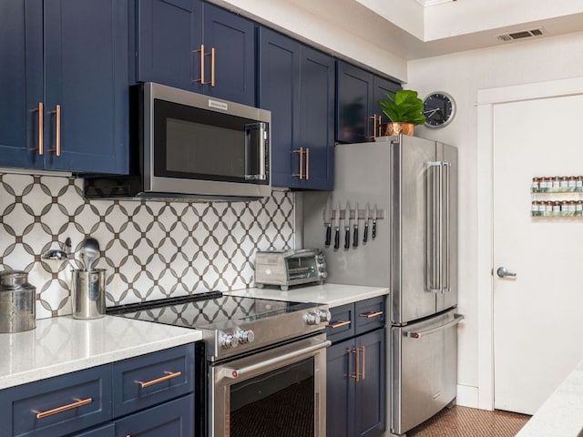 kitchen featuring blue cabinetry, a toaster, appliances with stainless steel finishes, and backsplash