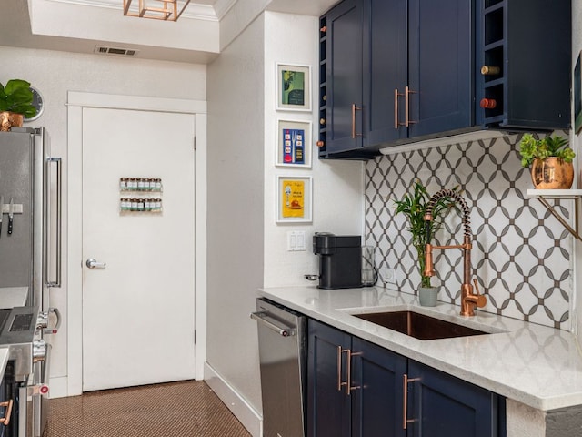 kitchen featuring visible vents, appliances with stainless steel finishes, a sink, blue cabinetry, and backsplash