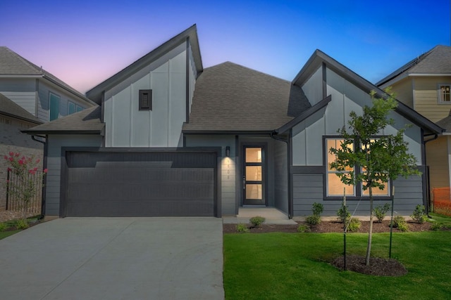 9908 Ephemeral Dr, Manor, TX 78653 - view of front of home with board and batten siding, driveway, a front lawn, a shingled roof, and a garage