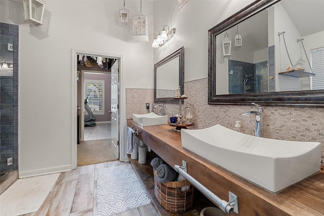 22128 Rose Grass Ln, Spicewood, TX 78669 - bathroom featuring tiled shower, double vanity, and backsplash