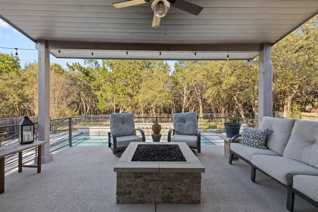 view of patio / terrace with a ceiling fan and an outdoor living space with a fire pit