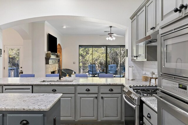 22128 Rose Grass Ln, Spicewood, TX 78669 - kitchen with gray cabinets, appliances with stainless steel finishes, arched walkways, a ceiling fan, and a peninsula