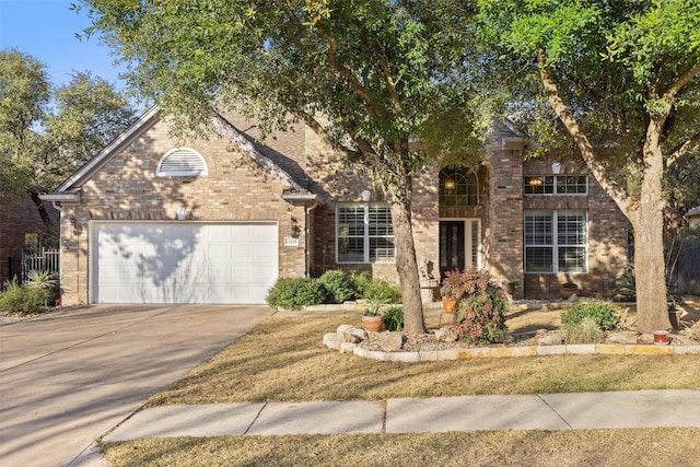 traditional-style home with a garage, driveway, and brick siding