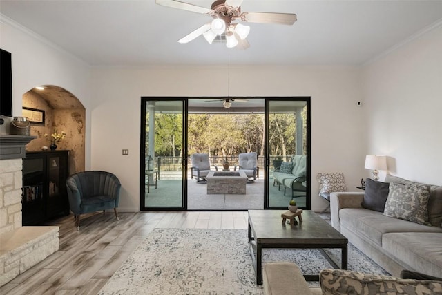 22128 Rose Grass Ln, Spicewood, TX 78669 - living area with light wood-type flooring, arched walkways, ceiling fan, crown molding, and baseboards