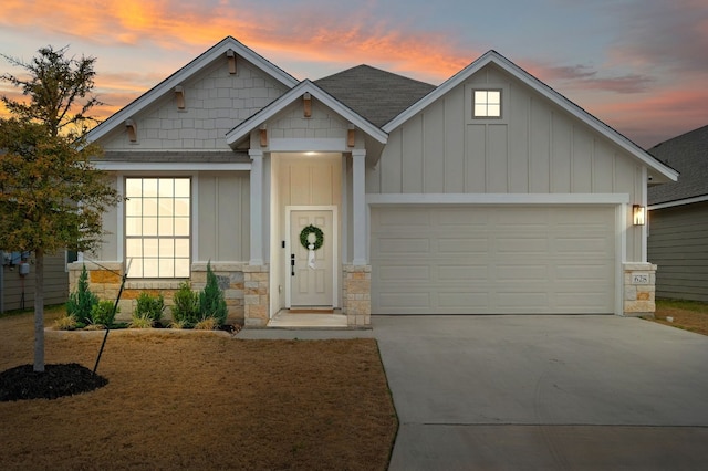 craftsman inspired home featuring an attached garage, driveway, and board and batten siding