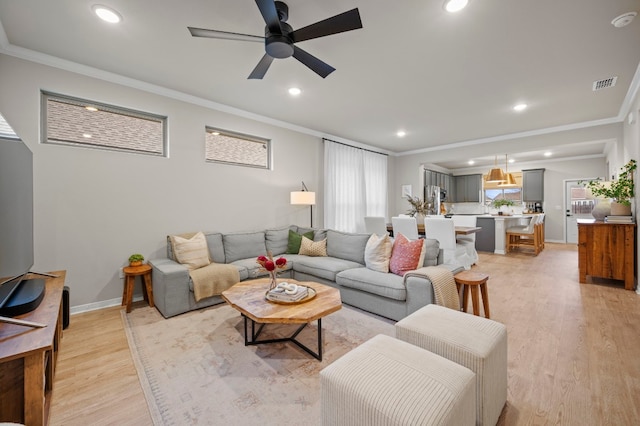 living area featuring light wood finished floors, ornamental molding, visible vents, and recessed lighting