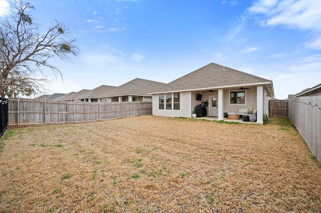 rear view of property with a yard, a patio area, a fenced backyard, and ceiling fan