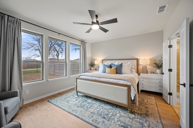 bedroom featuring light wood-style flooring, visible vents, ceiling fan, and baseboards