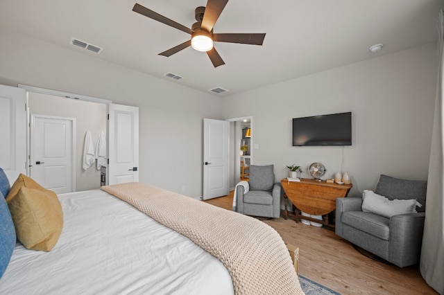 bedroom with light wood finished floors, visible vents, and a ceiling fan