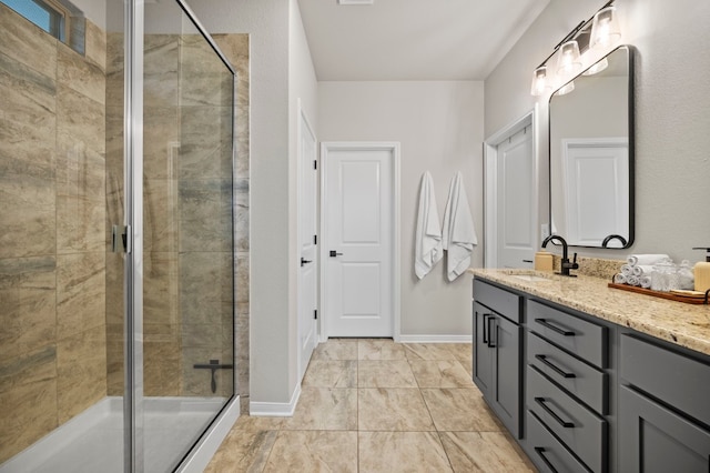 full bath with a stall shower, vanity, and baseboards