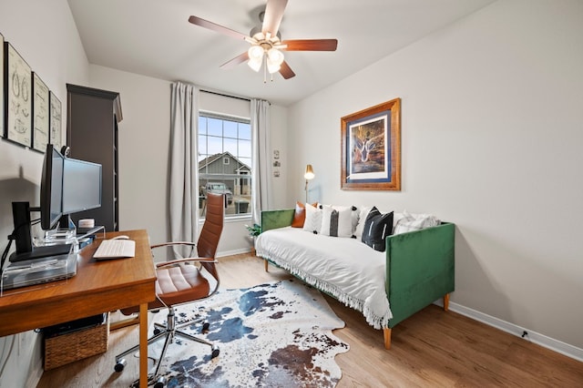 bedroom featuring light wood-type flooring, baseboards, and a ceiling fan